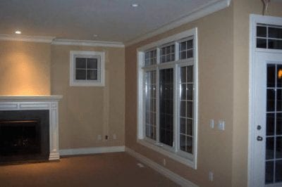 Large panel windows overlooking an empty room with a fireplace