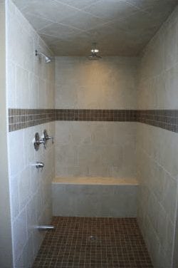 Large walk-in shower with a stone bench