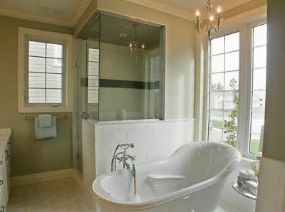 Large glass wall shower with bathtub beside it in a bathroom